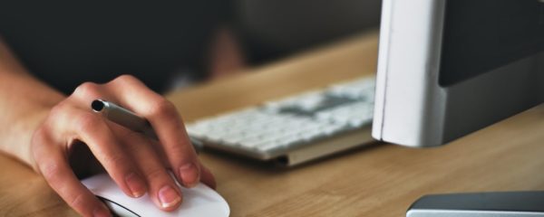 person holding apple magic mouse